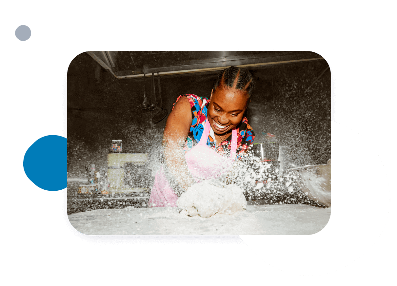 Person kneading dough with flour flying everywhere.